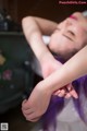 A woman with purple hair is getting her hair done.