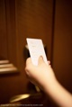 A person holding a white card in their hand.