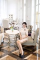 A woman sitting on a chair in a hotel lobby.