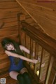 A woman in a blue bodysuit sitting on a wooden staircase.