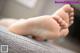 A close up of a person's bare feet on a couch.