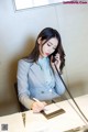 A woman sitting at a desk talking on a phone.