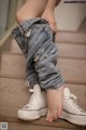 A woman is sitting on the stairs with her feet up.