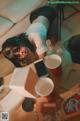 A woman laying on the floor next to a table with a cup of coffee.