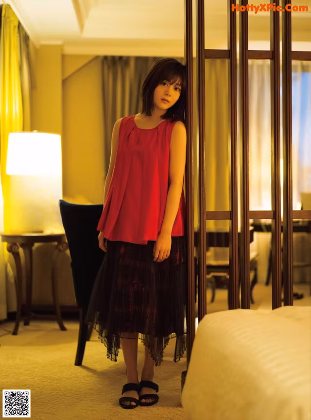 A woman standing in front of a mirror in a hotel room.