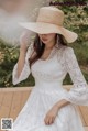 a woman wearing a white dress and a straw hat