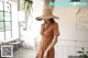 a woman wearing a straw hat standing in front of a window