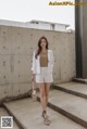 a woman standing in front of a concrete wall