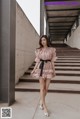 a woman in a pink dress standing on some steps