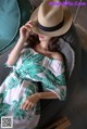 a woman wearing a straw hat sitting on a couch