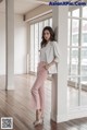 A woman leaning against a column in a room.