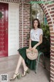 A woman sitting on a chair in front of a red door.