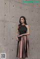 A woman standing in front of a concrete wall.