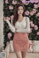 a woman in a white sweater and pink lace skirt