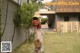 A woman in a straw hat is walking in the grass.