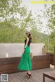 A woman wearing a green skirt and a straw hat.