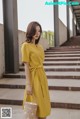 a woman in a yellow dress holding a basket