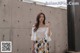 a woman standing in front of a concrete wall