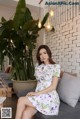 a woman sitting on a couch in a white dress