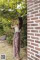 A woman standing in front of a brick wall.