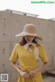 a woman wearing a yellow dress and a straw hat