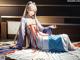 A woman in a blue and white kimono sitting on the floor.