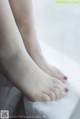 A close up of a woman's feet on a window sill.