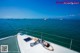 A woman laying on the deck of a boat in the ocean.