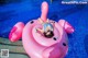 A woman laying on an inflatable flamingo in a swimming pool.