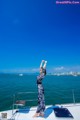 A woman standing on the deck of a boat in the ocean.