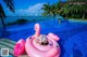 A woman laying on an inflatable flamingo in a swimming pool.