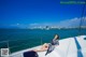 A woman sitting on the deck of a boat in the water.