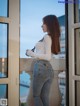 A woman standing on a balcony looking out a window.