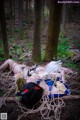 A woman laying on the ground in the woods.