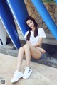 A woman sitting on the ground next to a blue slide.