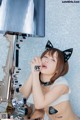 A woman wearing a cat ears headband sitting in front of a mirror.